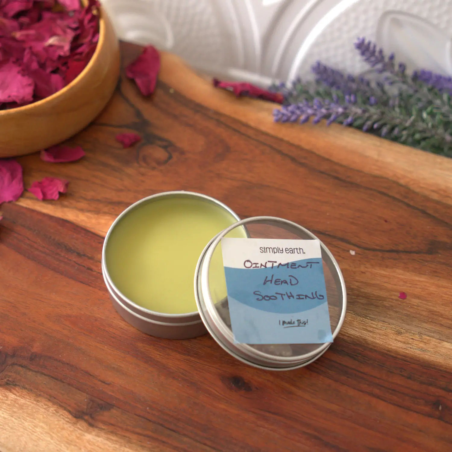 An open tin of homemade salve on a wooden board