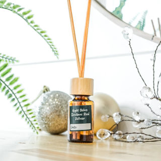 A homemade reed diffuser beside a silver holiday ornament