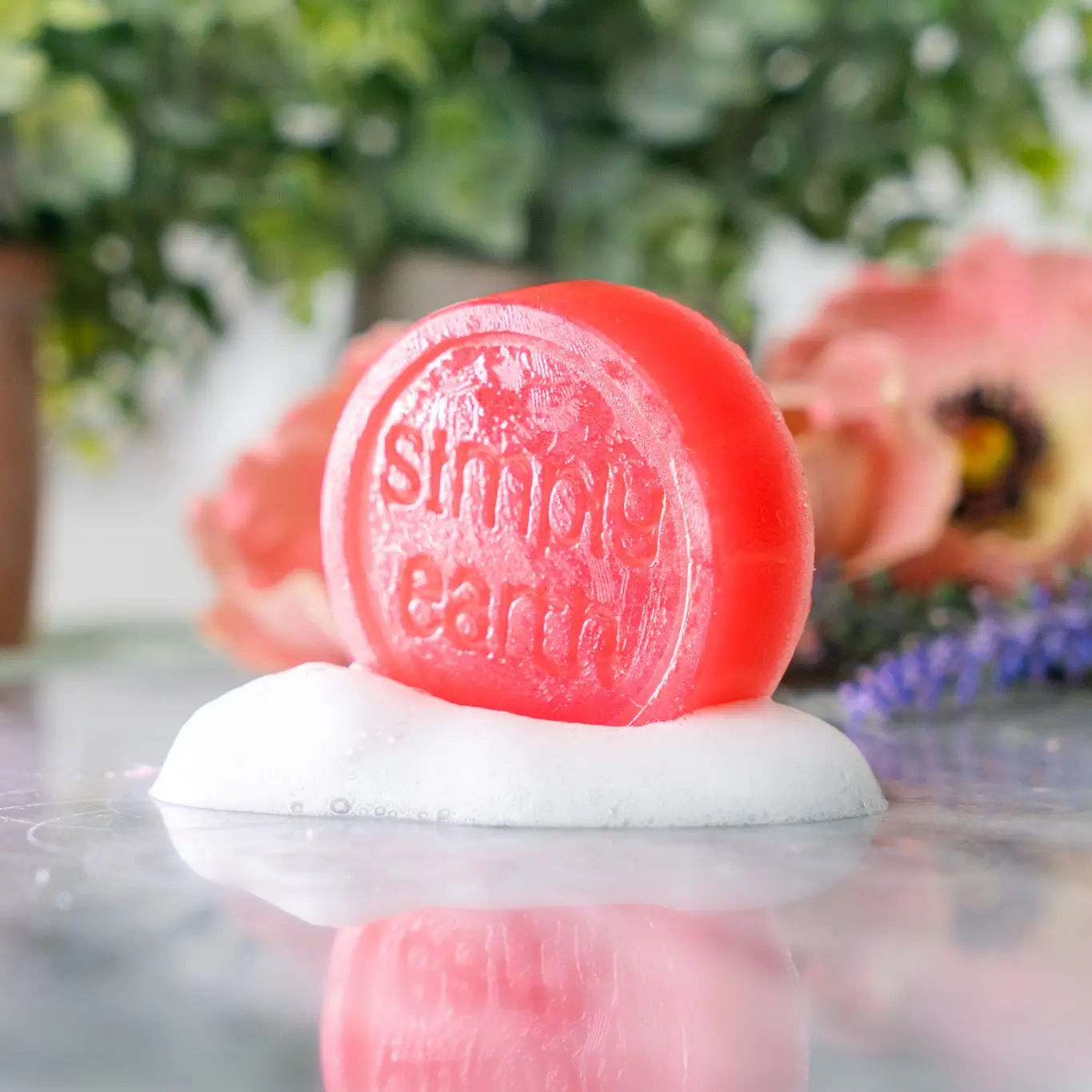 A red handmade soap bar stamped with the Simply Earth logo