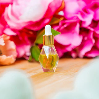A glass bottle of homemade face serum with a gold dropper