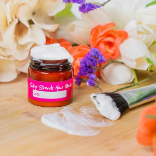 An amber jar of homemade hair mask among flowers