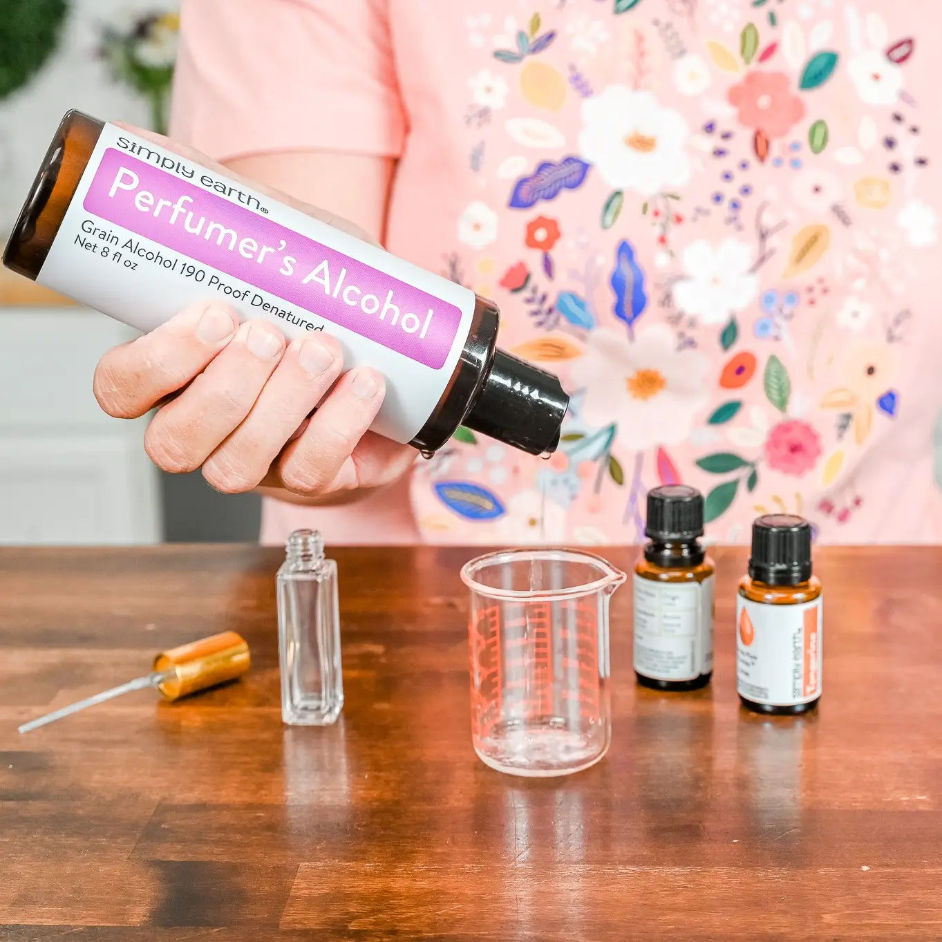 Someone pouring essential oils into melted soy wax at a candle making workshop