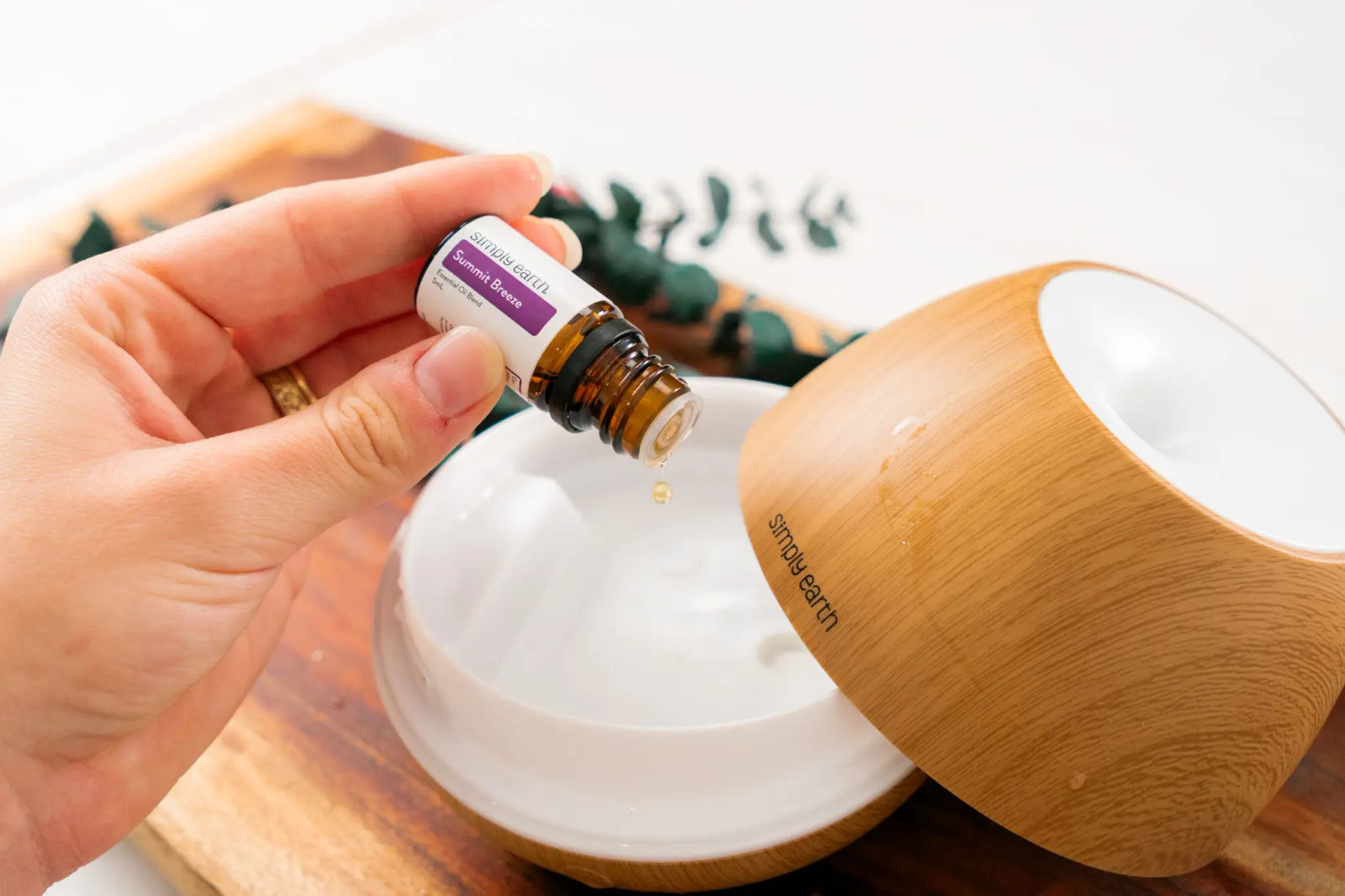 Summit Breeze diffuser blend dropped from its bottle into a wooden diffuser