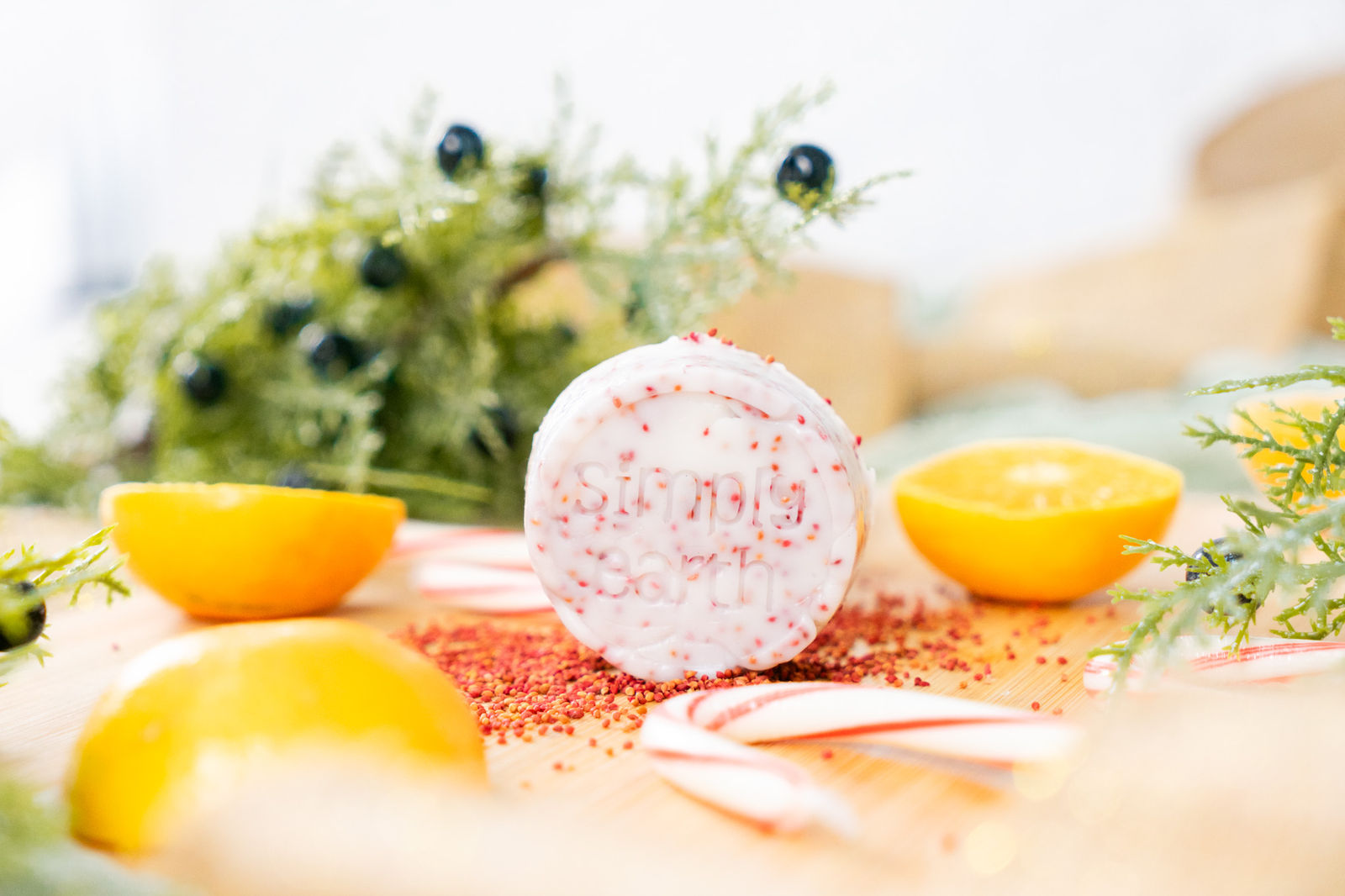A homemade Hearthside massage bar flecked with cranberry seeds, between orange halves